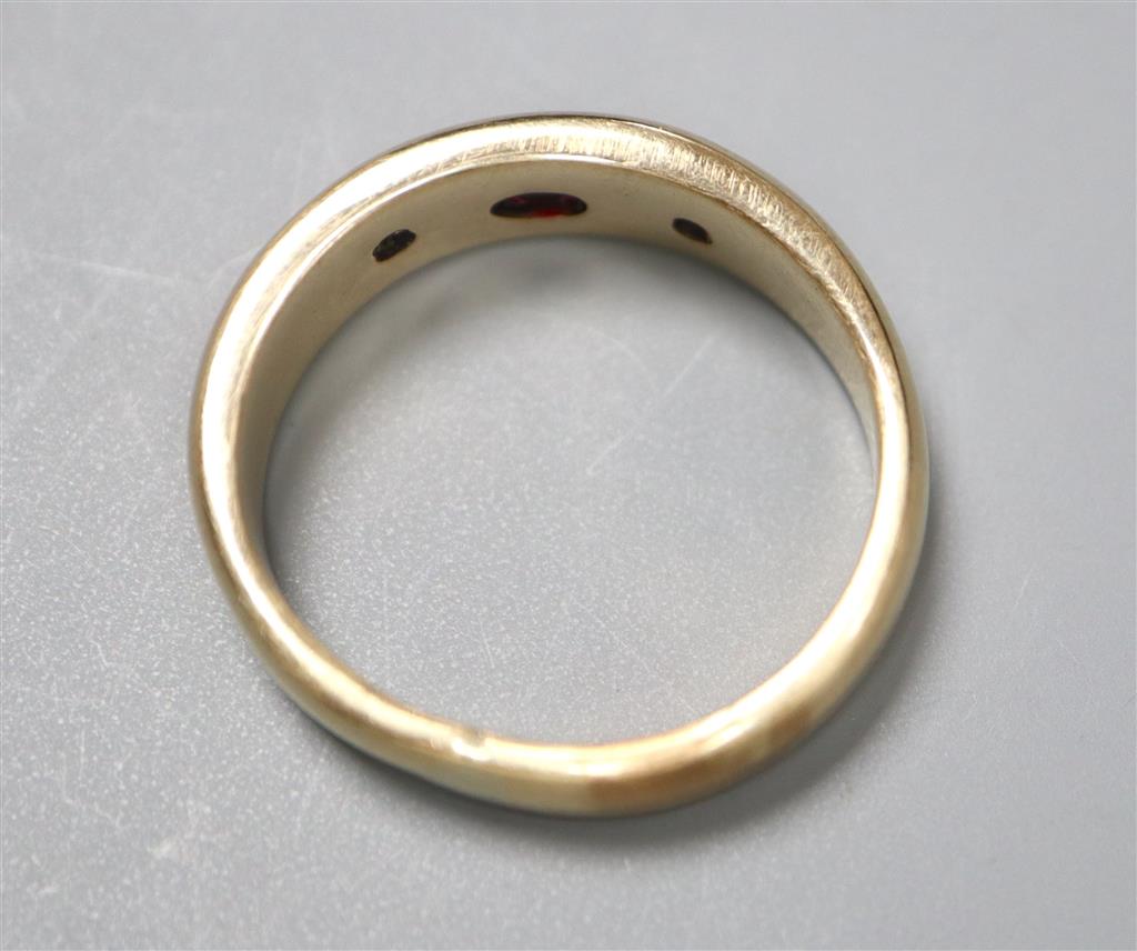 A yellow metal and gypsy set ruby and diamond three stone ring, size U/V, gross 8.9 grams.